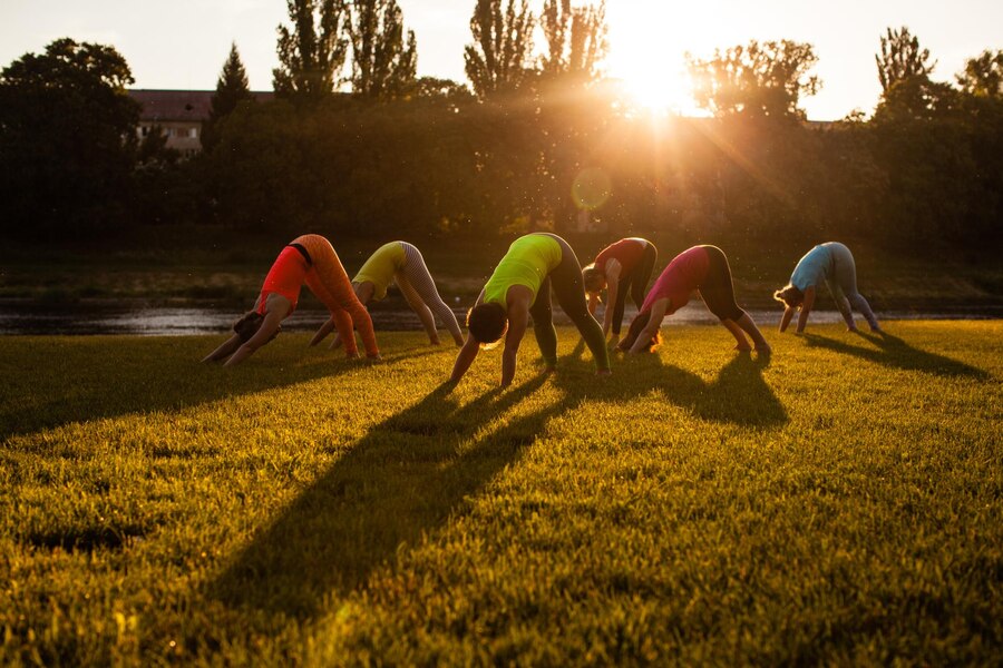 group-women-doing-yoga-by-river_290431-15746